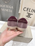 Maroon suede sneakers with white laces and logo on heel, back view.