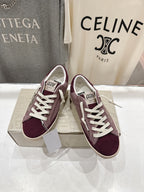 Maroon suede sneakers with white laces, side view, beige sole.