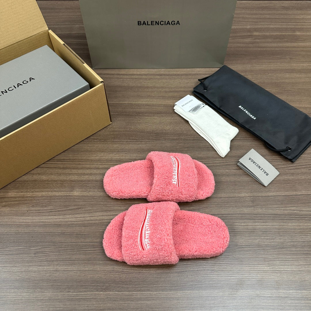 Pink terry slide sandals laid flat, Balenciaga logo stripe on the front straps.