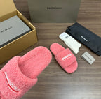 Pink terry slide sandals showing logo strap details, padded footbeds and open toe.