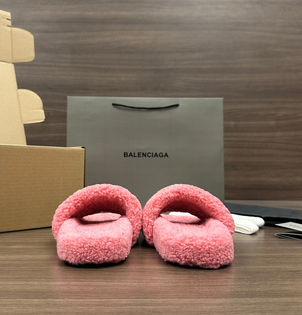 Pink fuzzy slide sandals with open toe, laid side by side, cushioned footbeds.