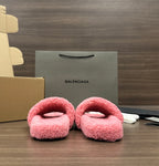 Pink fuzzy slide sandals with open toe, laid side by side, cushioned footbeds.