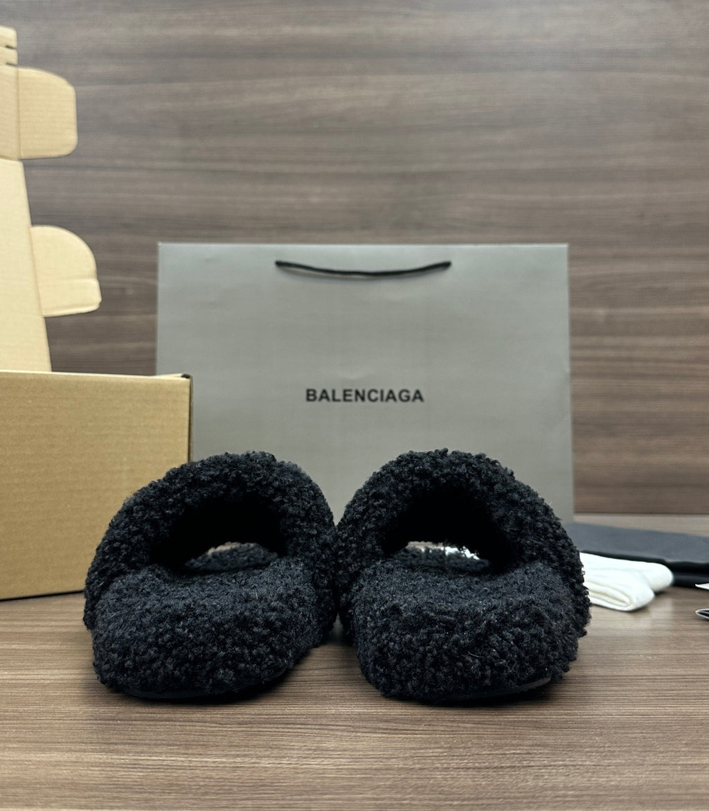 Black plush slide sandals, pair shown from front with cushioned band
