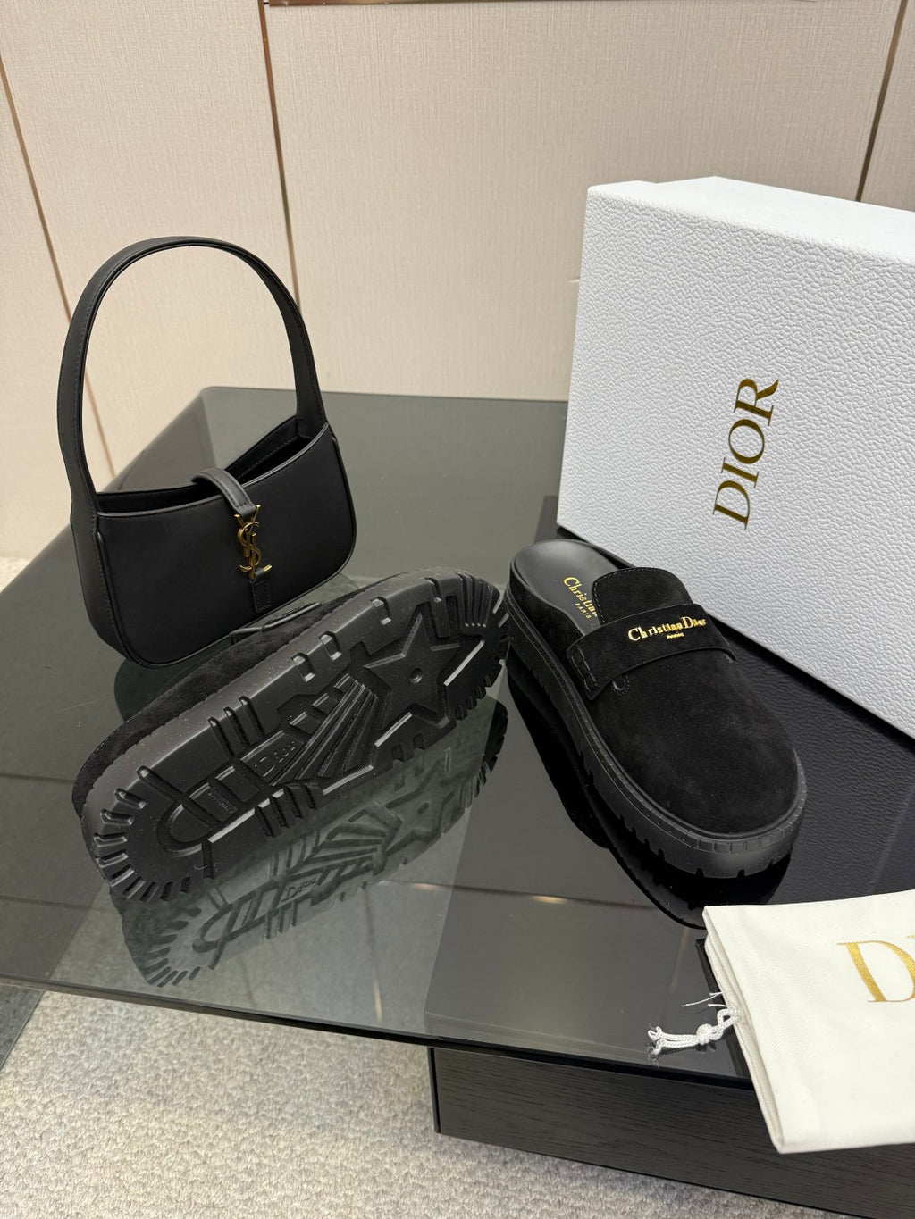 Black suede loafer with chunky tread outsole and gold buckle detail
