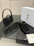 Black suede loafer with chunky tread outsole and gold buckle detail