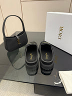 Black suede loafers, slip-on style with gold buckle detail and thick sole