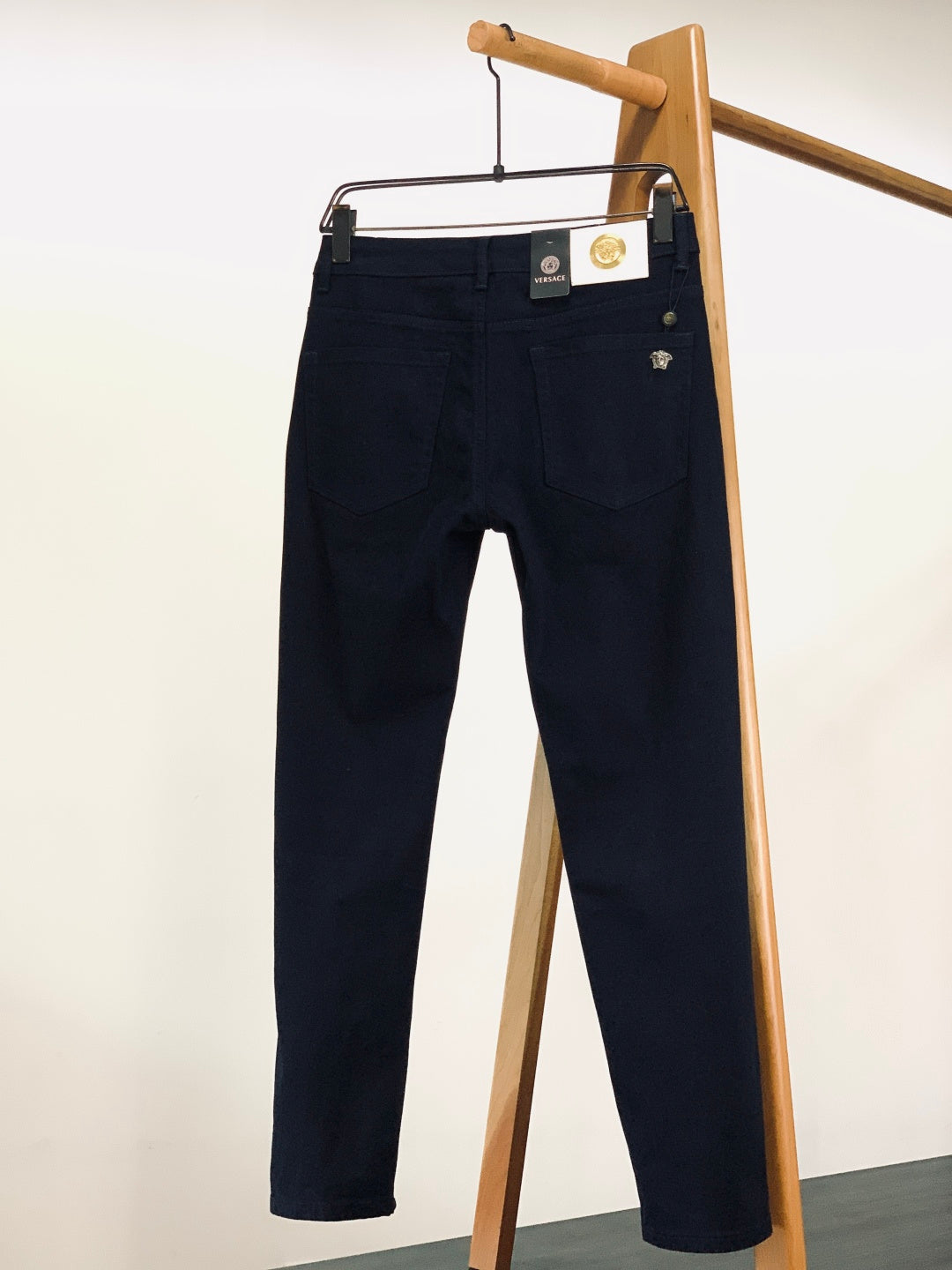 Navy denim trousers with logo patch on waistband and belt loops