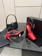 Red and black glossy stiletto heels with ankle straps on display