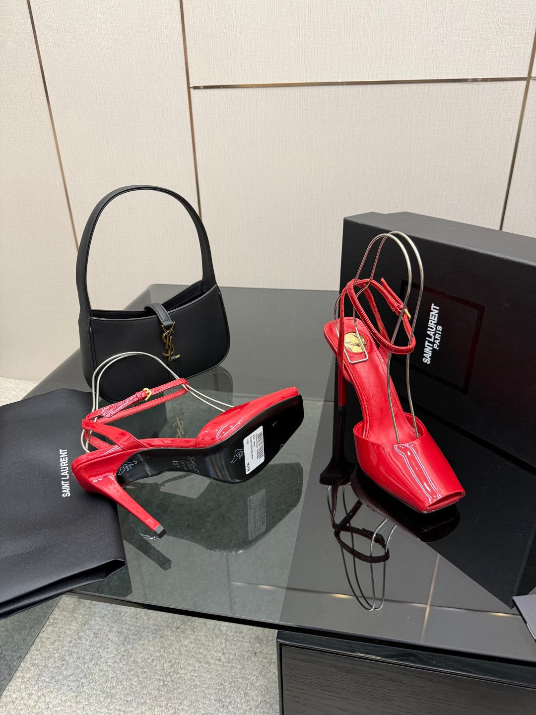 Red and black glossy stiletto heels with ankle straps on display