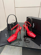 Red and black glossy stiletto heels with ankle straps and pointed toe