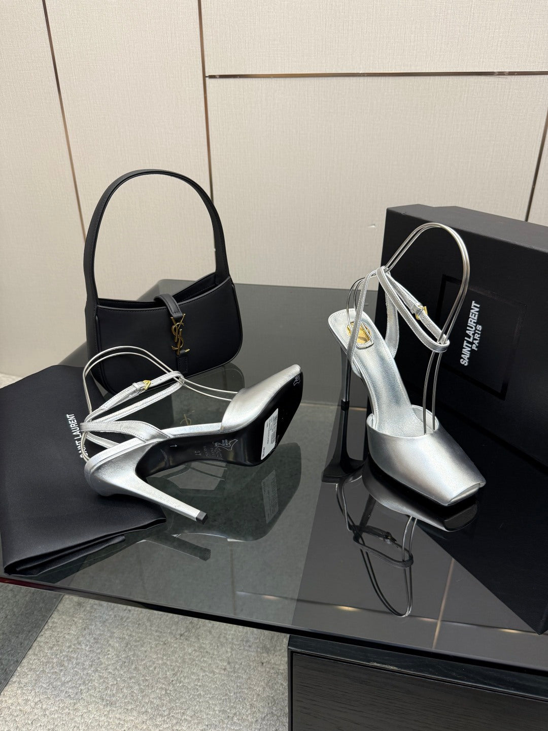 Silver and black high-heel sandals with thin straps and open toes.