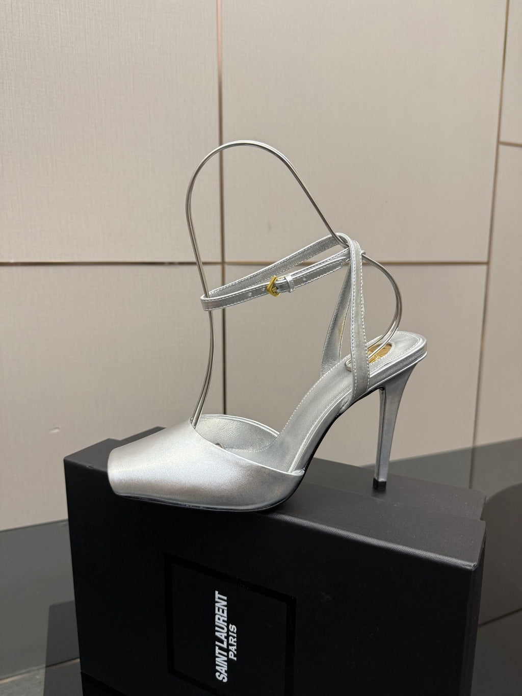 Silver open-toe high-heel sandal with thin ankle-strap and stiletto heel.