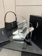 Silver strappy high-heel sandals with clear ankle strap and slim heel.