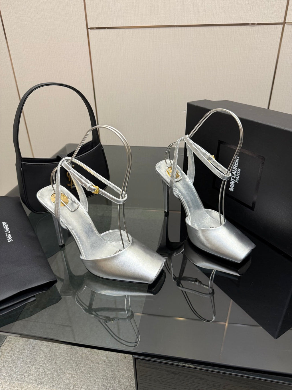 Pair of silver high-heel sandals with open toe and multiple thin straps.