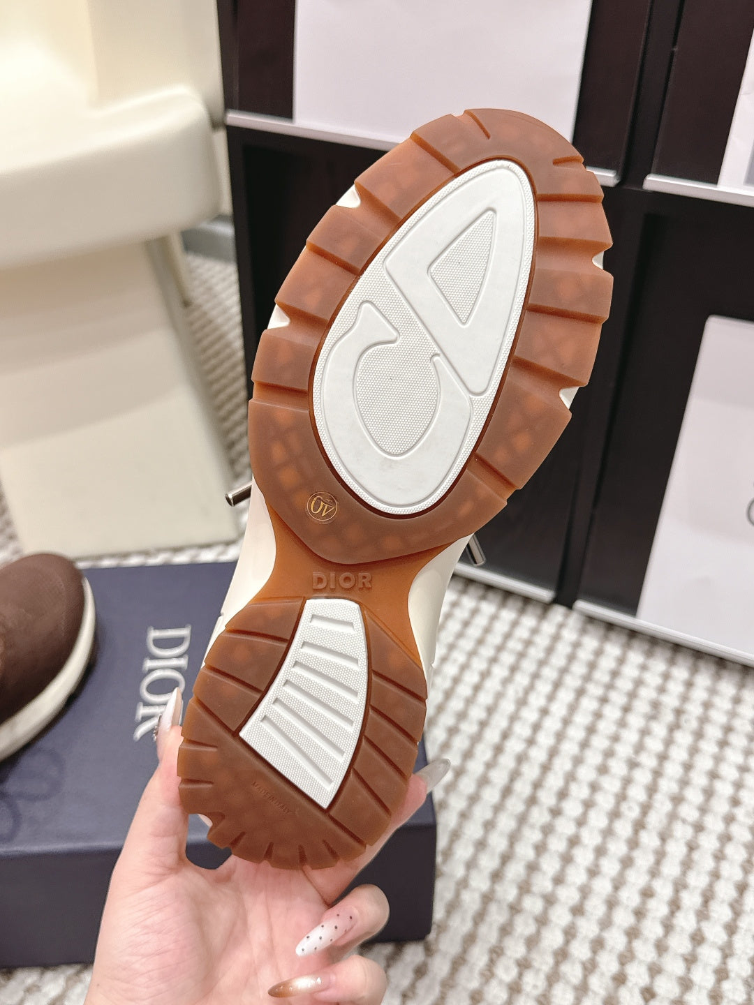 Outsole view of brown unisex sneaker with white tread and Dior branding