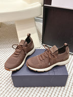 Pair of brown unisex knit lace-up sneakers on a shoe box