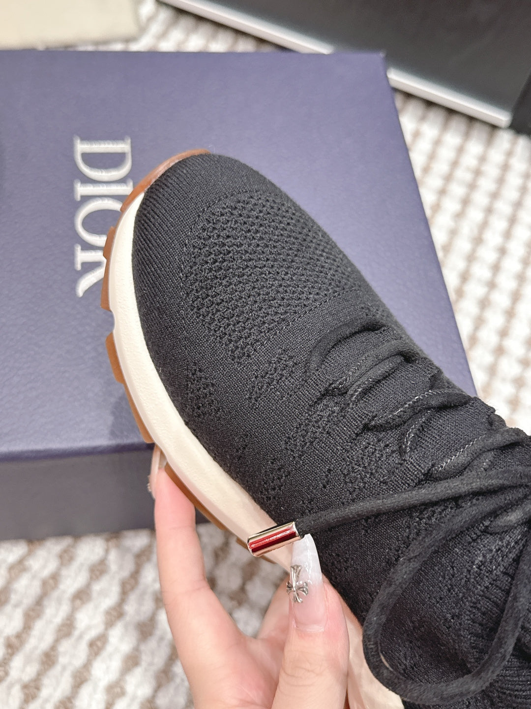 Black Dior unisex sneaker upper close-up with laces and metal eyelet accent