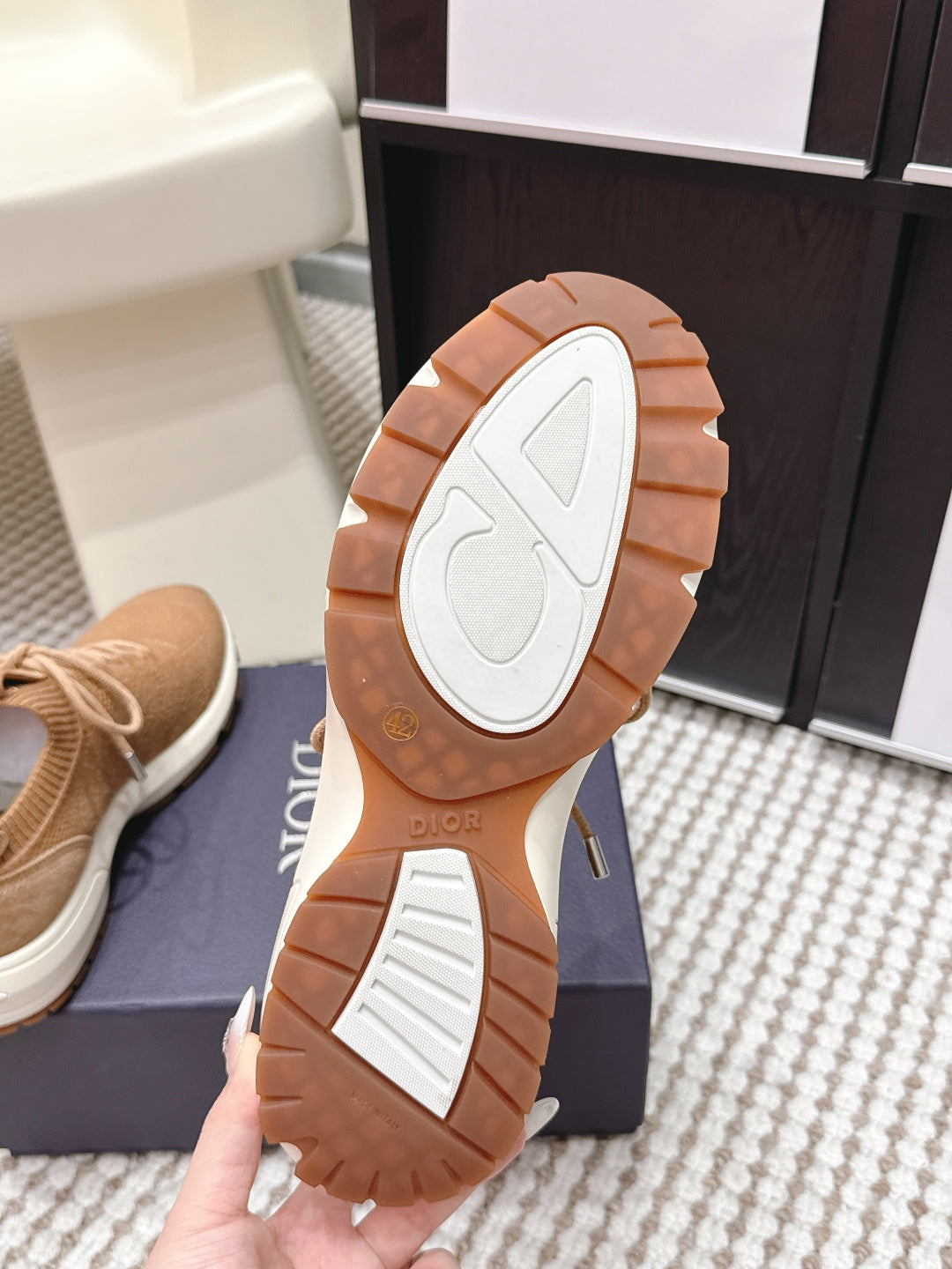 Beige Dior sneaker outsole view with brown rubber tread and brand markings