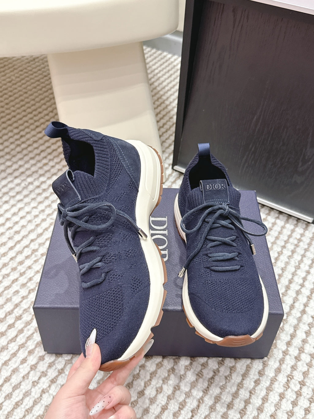Navy knit sneakers with lace-up closure, white sole, and Dior logo on tongue