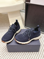Navy lace-up knit sneakers on a box with thick white sole and Dior tongue patch