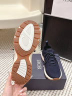 Navy lace-up knit sneakers with treaded white sole and Dior branding on heel