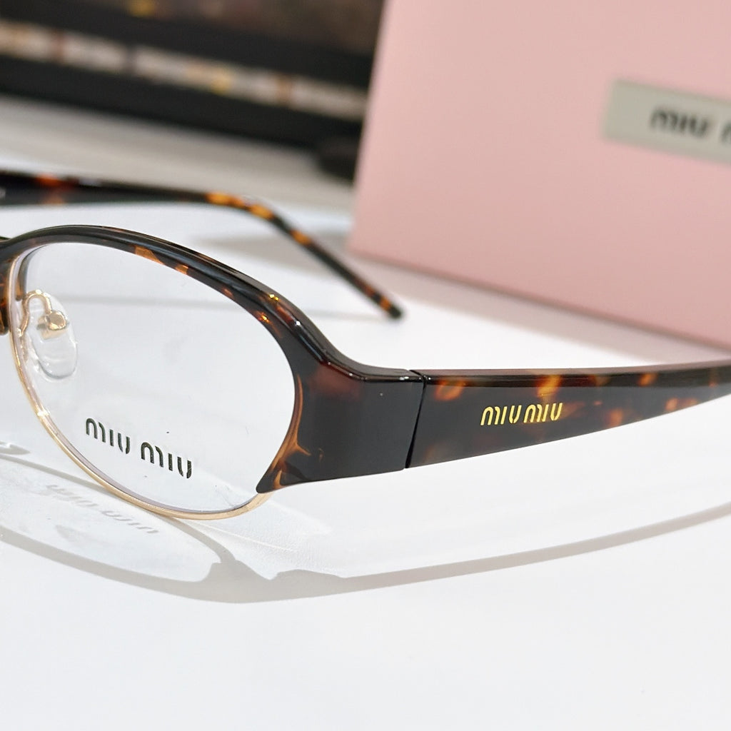 Miu miu eyeglasses close-up: dark front frame with tortoiseshell temple, clear lenses