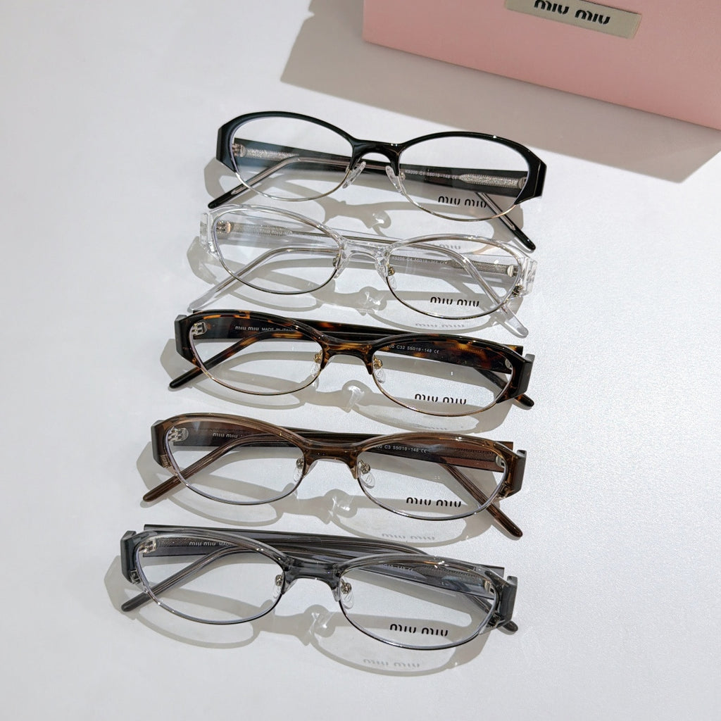 Stacked Miu miu eyeglasses set with clear lenses and mixed frame colors, rectangular shapes