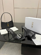 Black studded slide sandals with silver buckle detail on high heels