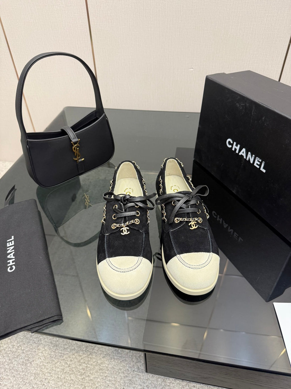 Chanel women’s lace-up sneakers in dark fabric with white toe caps and chain detail