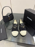 Chanel women’s lace-up sneakers in dark fabric with white toe caps and chain detail