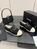 Chanel women’s lace-up sneakers, black with white toe panels and gold chain accents