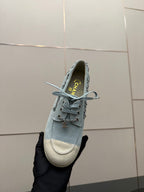 Chanel women's light-blue sneaker close-up with heel logo and lace-up laces