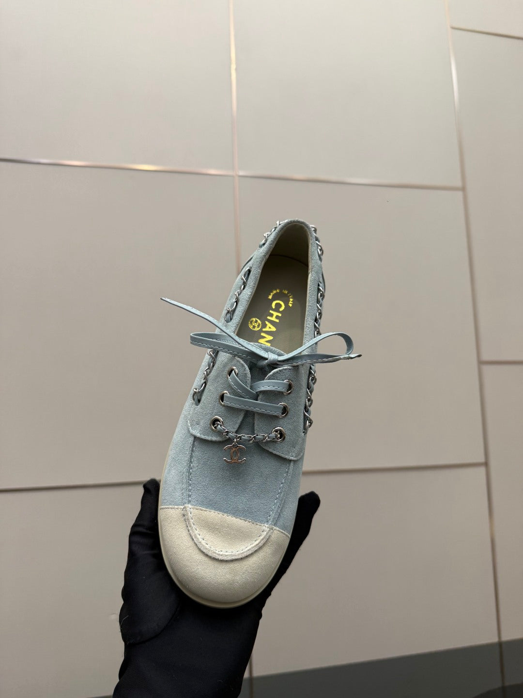 Chanel women's light-blue sneaker close-up with heel logo and lace-up laces