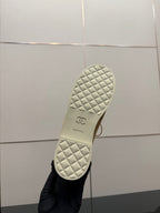 Ladies tan sneaker outsole view, quilted white tread with small logo mark