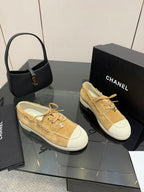 Ladies tan suede low sneakers with white side panels and lace-up closure