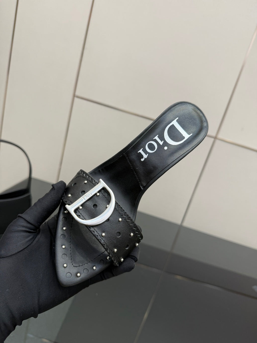 Black mule sandal with silver buckle strap and Dior logo on slide