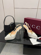 White Gucci slingback heels with gold chain ornament and stiletto heel