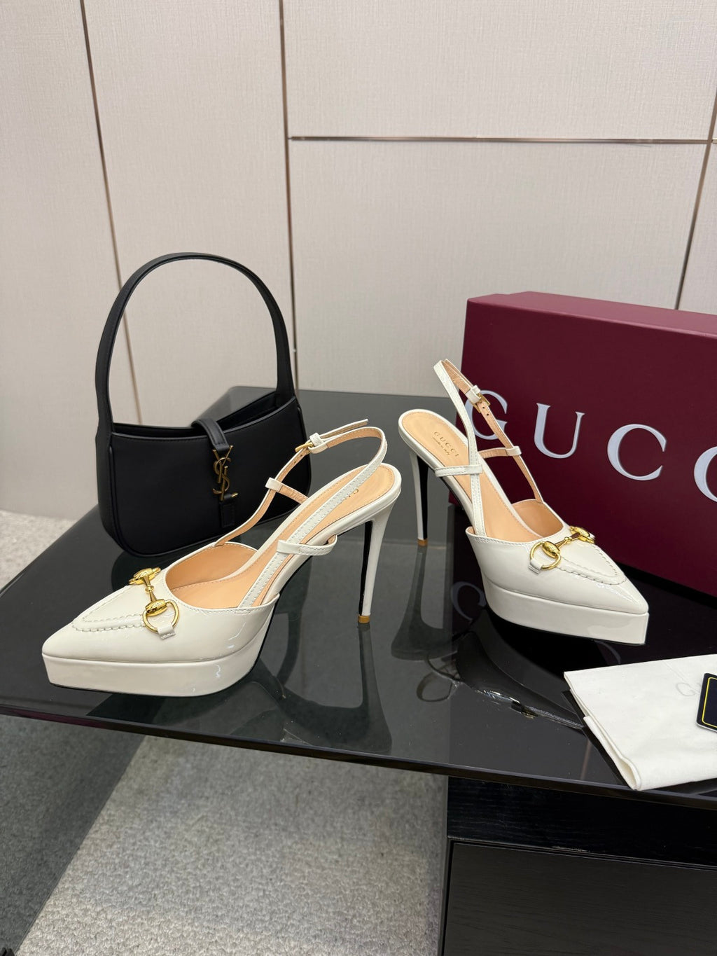 Pair of white Gucci slingback heels with gold buckle and stiletto heel