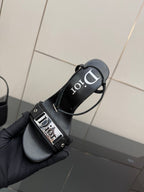 Black heeled sandal showing Dior logo buckle and thin cross straps.