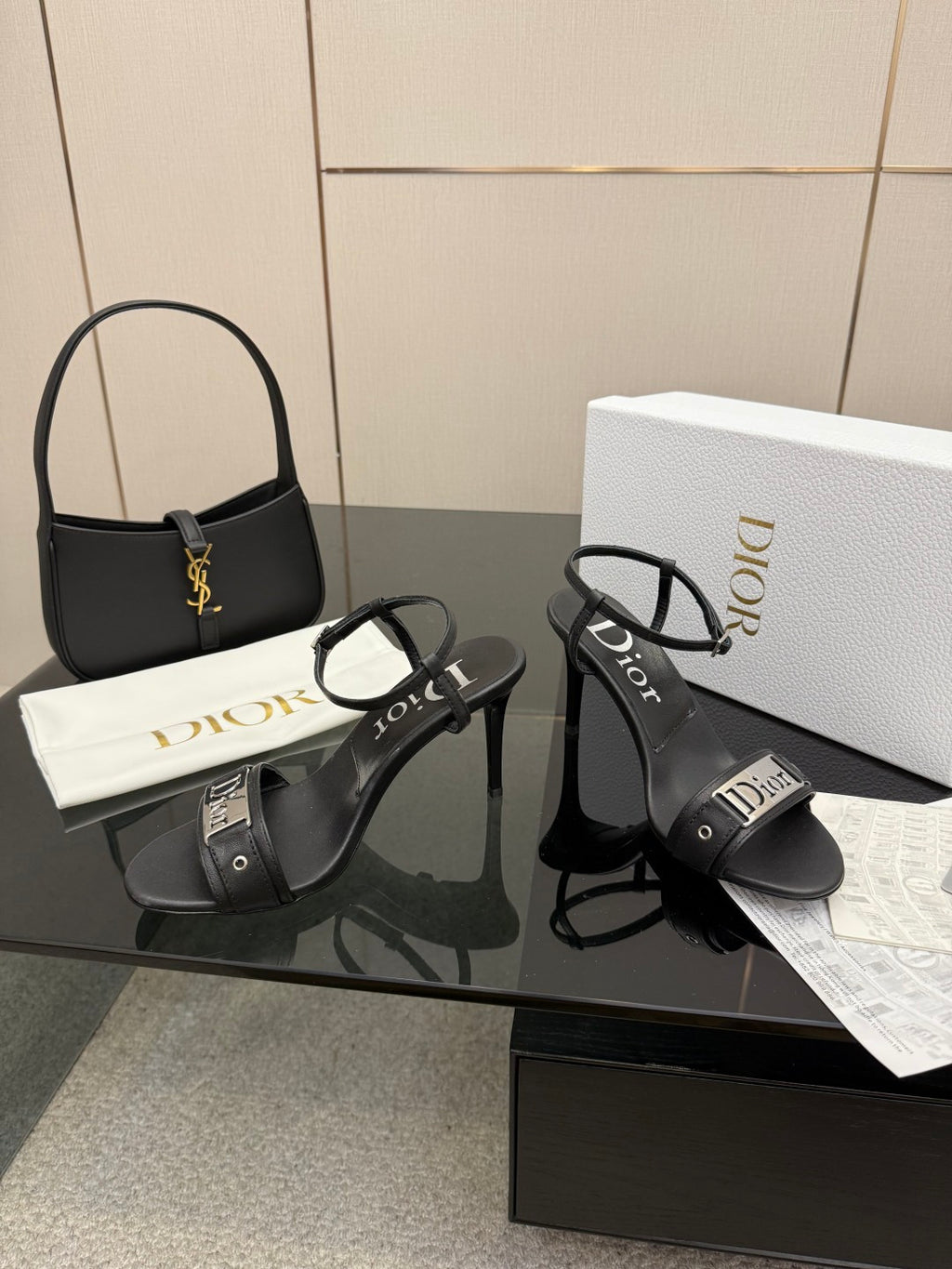 Black heeled sandals with ankle buckle straps and Dior logo on the band.