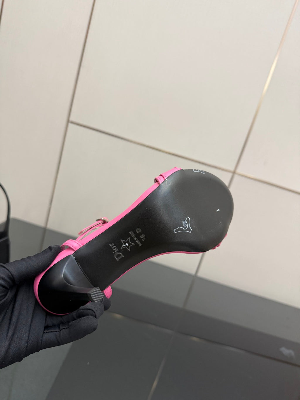 Pink Dior ladies sandal outsole bottom view, grip texture with small logo markings.