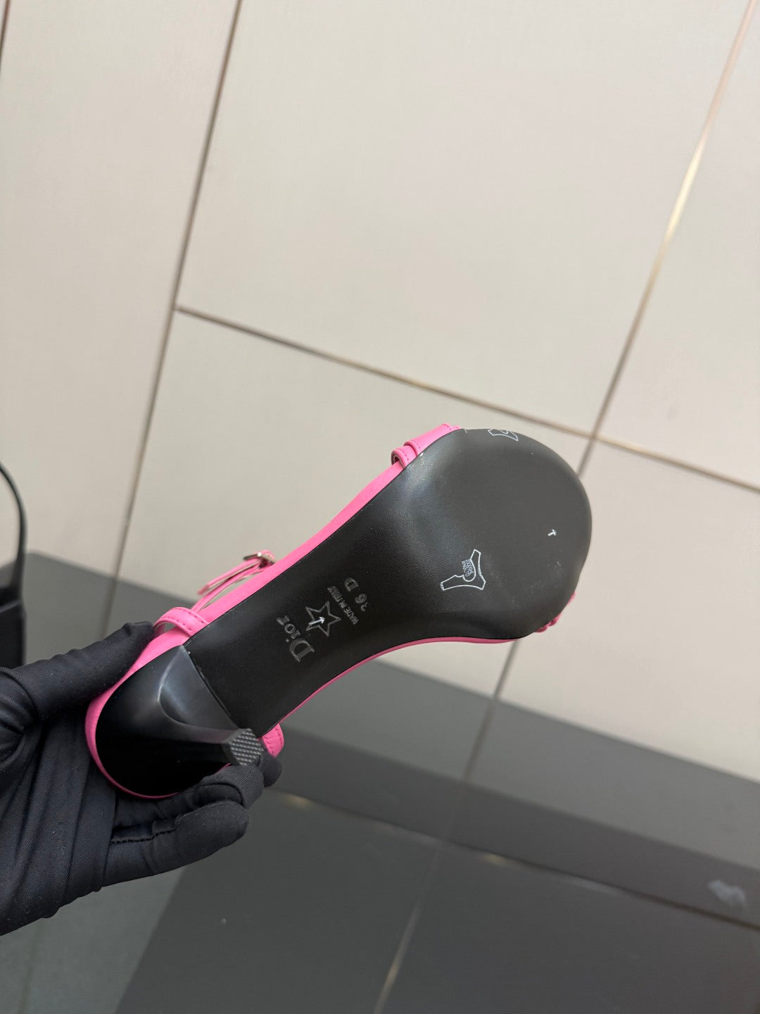 Pink Dior ladies sandal outsole bottom view, grip texture with small logo markings.