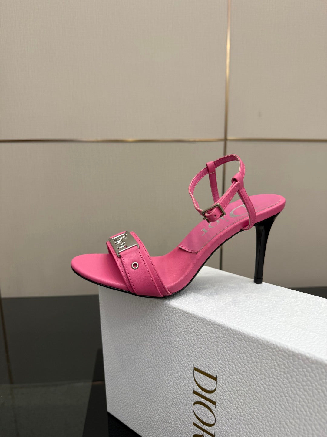 Pink Dior ladies heeled sandal on box, open-toe design with ankle strap and buckle.