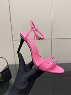 Pink Dior ladies heeled sandals with ankle strap and buckle detail, hand-held angled view.
