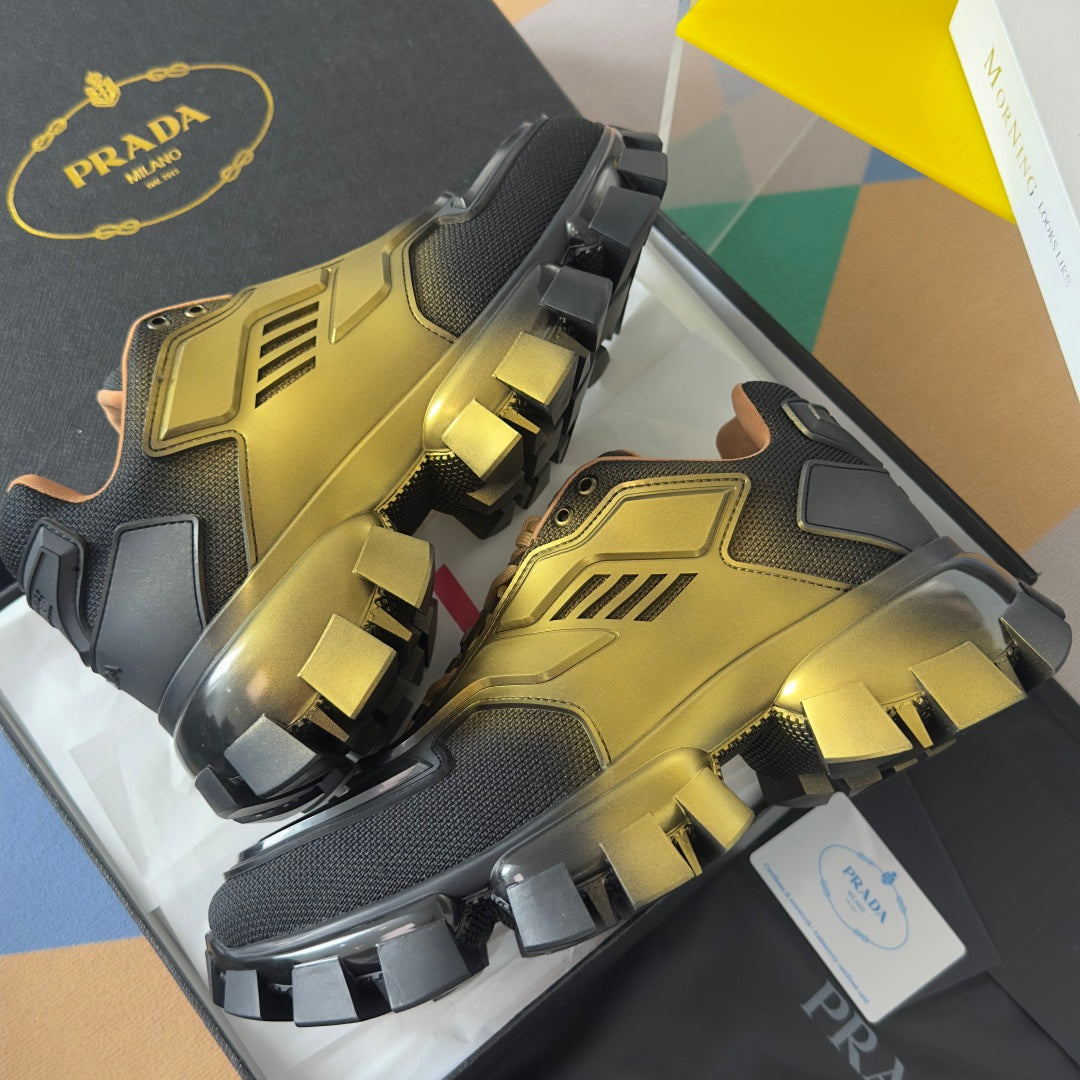 Prada unisex sneakers with metallic gold tops and black side straps over lug sole