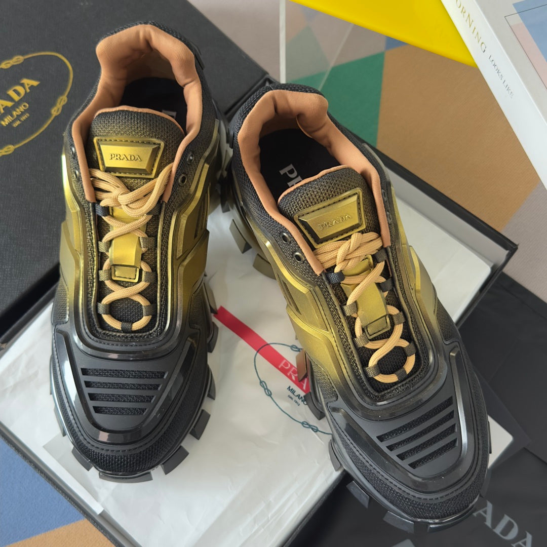 Prada unisex lace-up sneakers showing gold laces and metallic gold upper with black sole