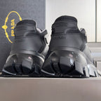 Prada chunky sneakers back view, black uppers with embossed logo on heel