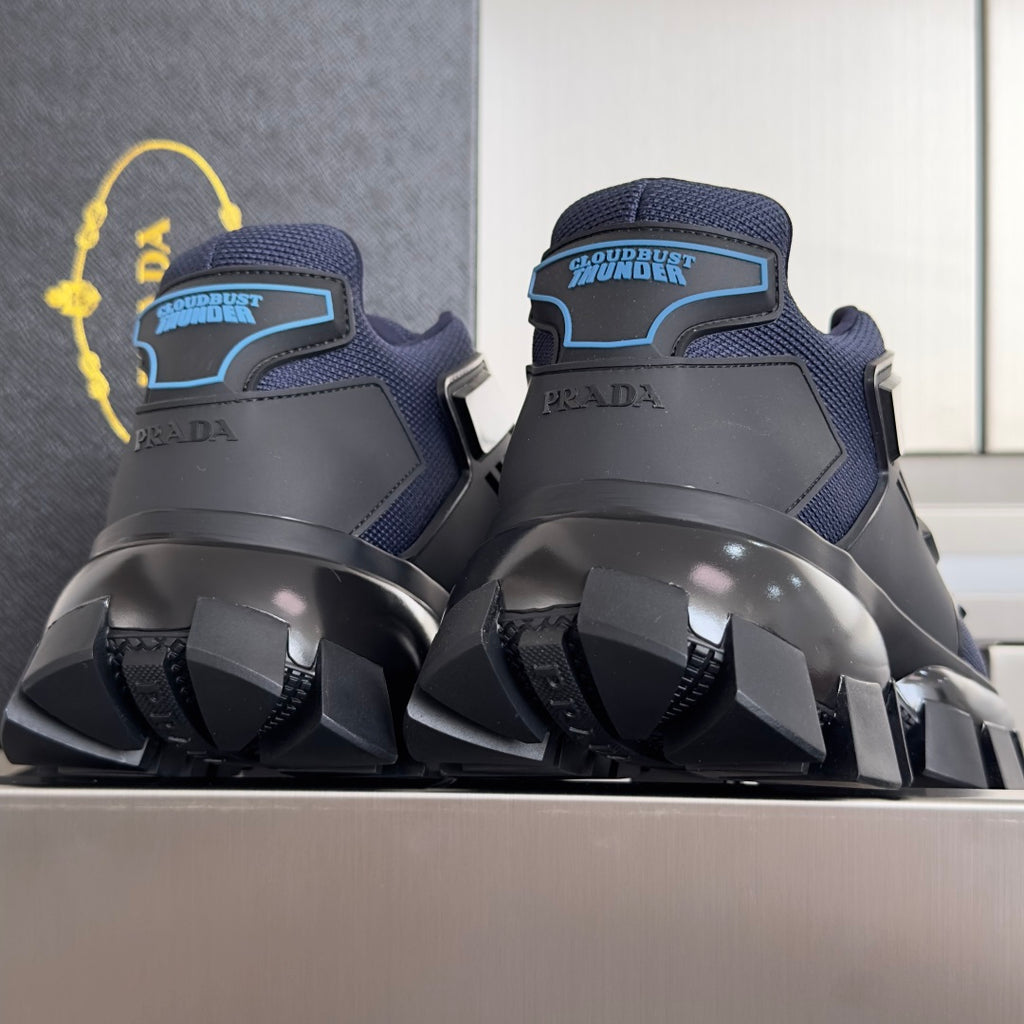 Unisex sneakers with dark blue uppers, PRADA branding, and black heel tread.