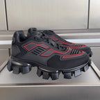 Prada unisex sneakers with dark mesh upper, red accents, and chunky lug sole