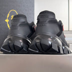 Prada unisex sneakers back view, dark uppers with red accents and thick lug heel